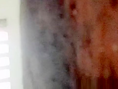 Asian woman spied over the toilet wall taking a pee
