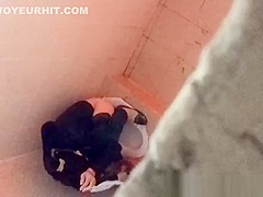 Asian woman spied over the toilet wall taking a pee