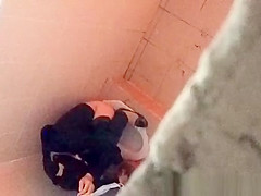Asian woman spied over the toilet wall taking a pee
