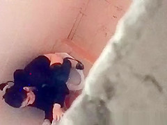 Asian woman spied over the toilet wall taking a pee