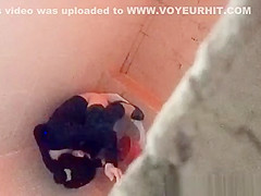 Asian woman spied over the toilet wall taking a pee