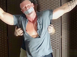 Bound muscular dude endures tickling from a mature deviant