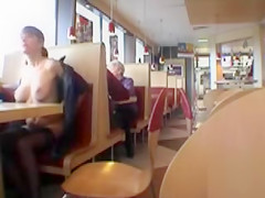 Brunette MILF flashing her jugs in a restaurant