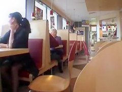 Brunette MILF flashing her jugs in a restaurant