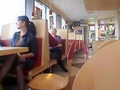 Brunette MILF flashing her jugs in a restaurant