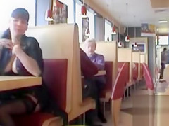 Brunette MILF flashing her jugs in a restaurant