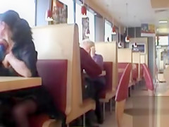 Brunette MILF flashing her jugs in a restaurant
