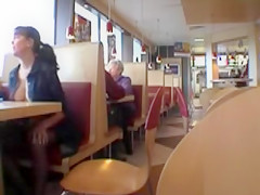 Brunette MILF flashing her jugs in a restaurant
