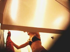 Girl in a dressing room puts on tiny top and candid shorts