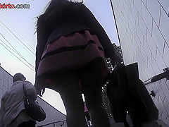 Long-legged brunette shows g-string in candid upskirts
