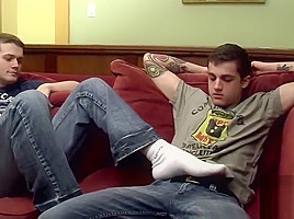 Tattooed twink gets a footjob before getting to blow cock