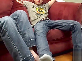 Tattooed twink gets a footjob before getting to blow cock